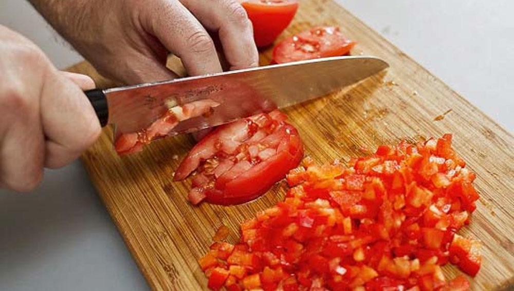 Нарезание помидора на мелкие кубики Помидор и нож